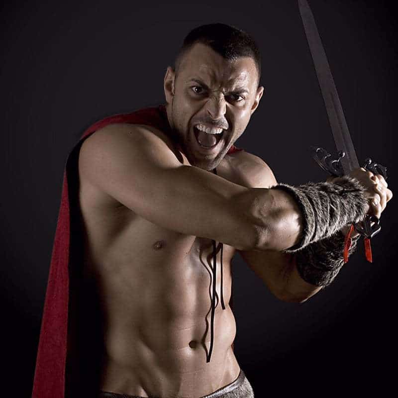 Joel Acosta strippers Barcelona posando en un traje espartano con una espada
